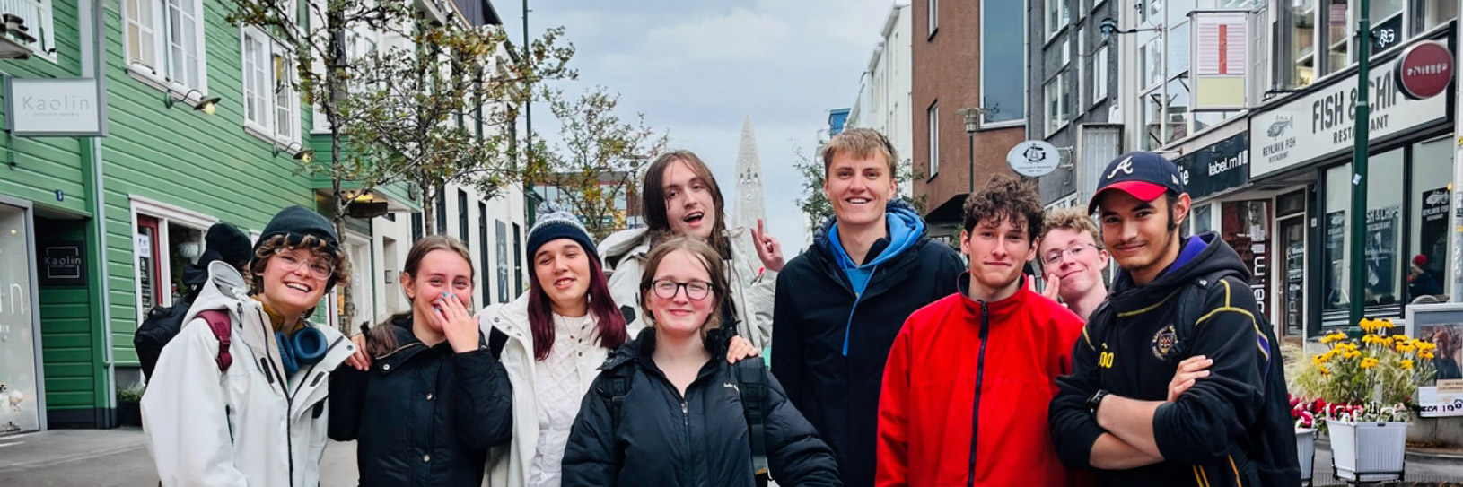 Group of students standing on a cobblestone street in Reykjavík, Iceland, with the Hallgrímskirkja church visible in the background